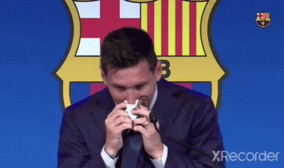 A Man In A Suit And Tie Wipes His Nose With A Napkin In Front Of A Fcb Logo GIF