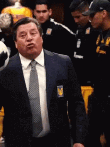 A Man In A Suit And Tie With A Badge That Says Tigres GIF