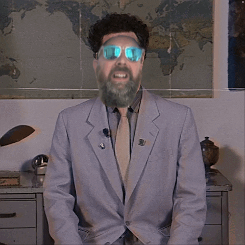 A Man In A Suit And Tie With A Beard Wearing Sunglasses GIF
