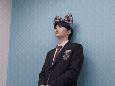 A Man In A Suit And Tie With A Bow On His Head Is Making A Face GIF