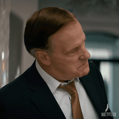 A Man In A Suit And Tie With A Netflix Logo On The Bottom Right GIF