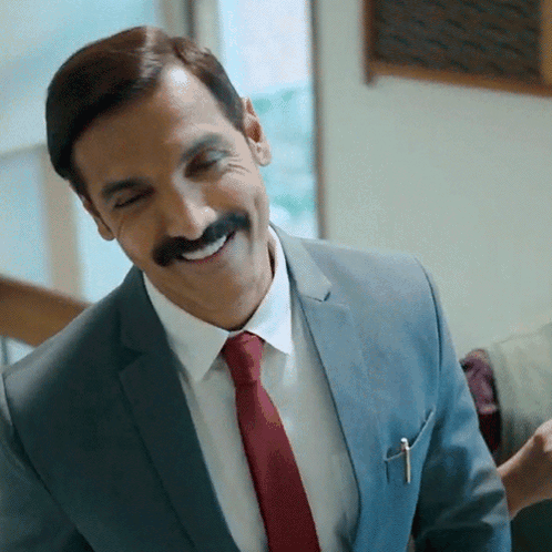 A Man In A Suit And Tie With A Pen In His Pocket GIF