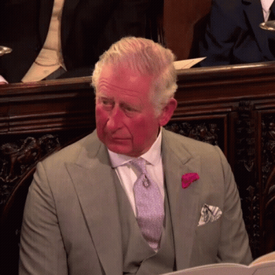 A Man In A Suit And Tie With A Pink Flower Pin On His Pocket Square GIF