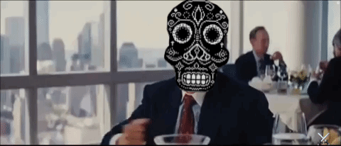 A Man In A Suit And Tie With A Sugar Skull On His Face GIF