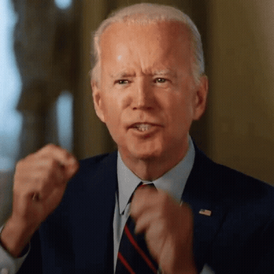 A Man In A Suit And Tie With An American Flag Pin GIF