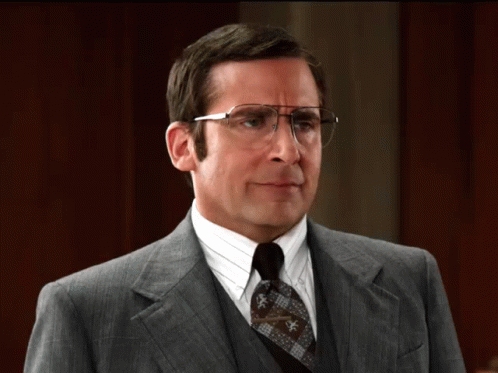 A Man In A Suit And Tie With Glasses GIF