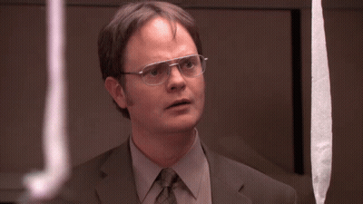 A Man In A Suit And Tie With Glasses Looks At Something GIF