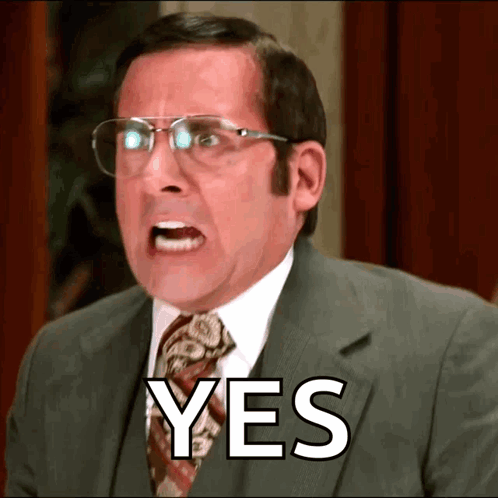 A Man In A Suit And Tie With Glasses Says Yes GIF