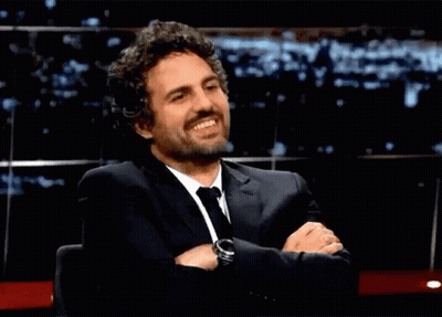 A Man In A Suit And Tie With His Arms Crossed GIF