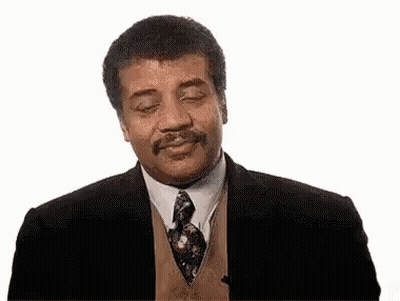 A Man In A Suit And Tie With His Eyes Closed Is Smiling . GIF