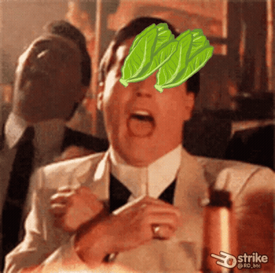 A Man In A Suit And Tie With Lettuce Leaves On His Face GIF