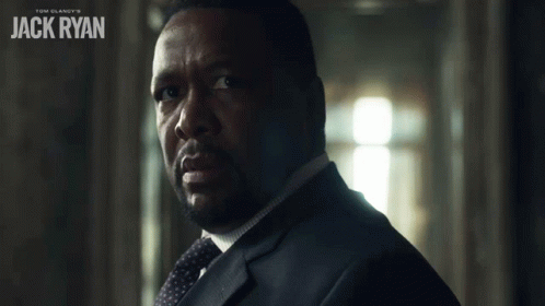 A Man In A Suit And Tie With The Name Jack Ryan On The Bottom GIF