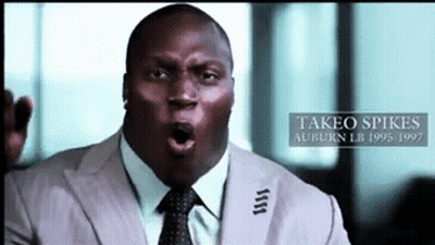A Man In A Suit And Tie With The Name Takeo Spikes On The Bottom Right GIF