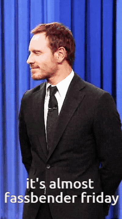 A Man In A Suit And Tie With The Words It 'S Almost Fassbender Friday Below Him GIF