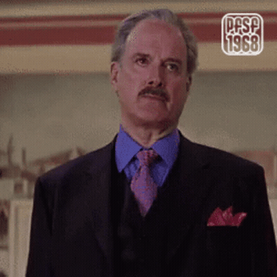 A Man In A Suit And Tie With The Year 1968 On The Corner GIF