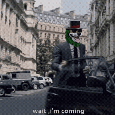 A Man In A Suit And Top Hat Says Wait I 'M Coming As He Gets Out Of A Car GIF