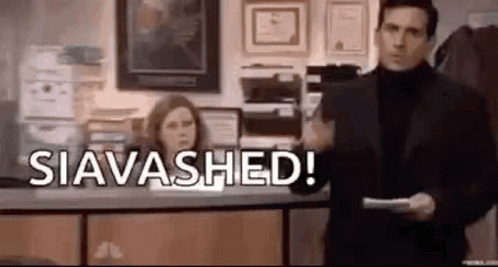 A Man In A Suit And Turtleneck Is Holding A Piece Of Paper In Front Of A Woman . GIF