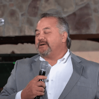 A Man In A Suit And White Shirt Holds A Microphone With His Eyes Closed GIF