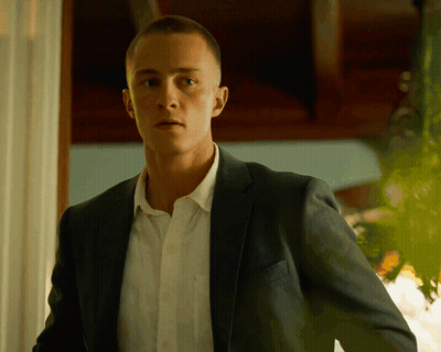 A Man In A Suit And White Shirt Is Looking At The Camera GIF
