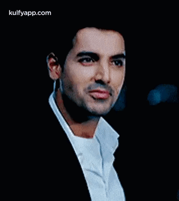 A Man In A Suit And White Shirt Is Looking At The Camera With A Serious Look On His Face . GIF