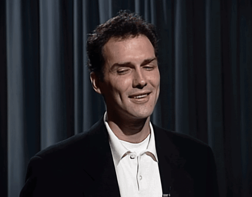 A Man In A Suit And White Shirt Is Smiling GIF