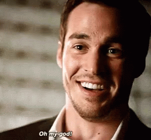 A Man In A Suit And White Shirt Is Smiling And Saying `` Oh My God '' . GIF