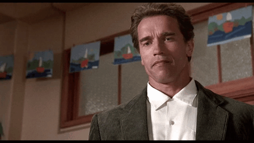 A Man In A Suit And White Shirt Is Standing In Front Of A Window With Sailboats On It . GIF