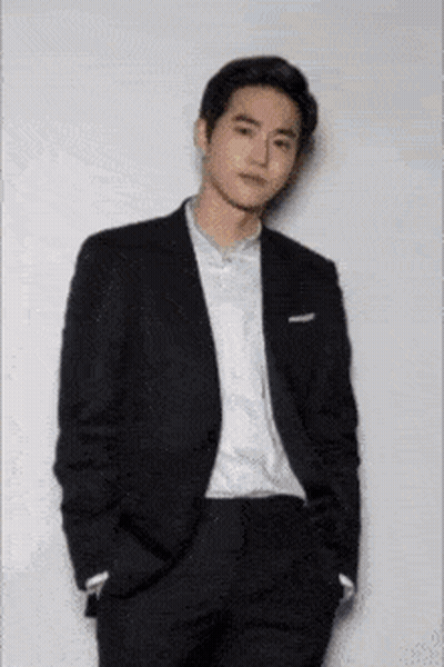 A Man In A Suit And White Shirt With His Hands In His Pockets . GIF