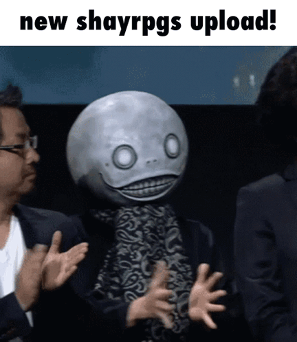 A Man In A Suit Applauds Next To A Man With A Mask On His Head That Says " New Shayrpgs Upload " GIF