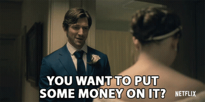 A Man In A Suit Asks A Woman If She Wants To Put Some Money On Her GIF