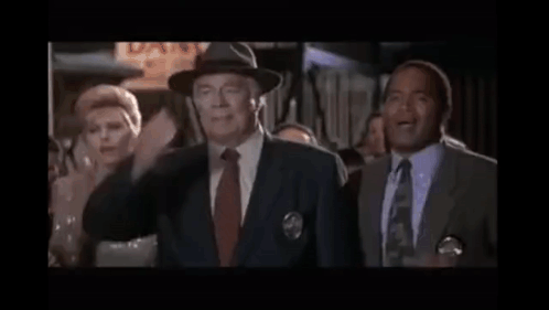 A Man In A Suit Covering His Eyes With His Hand GIF