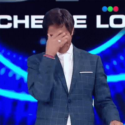 A Man In A Suit Covering His Face With His Hand GIF