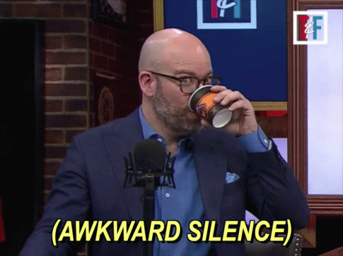 A Man In A Suit Drinking From A Cup With The Words Awkward Silence Below Him GIF