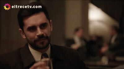 A Man In A Suit Drinking From A Glass With Eltrecetv.com Written On The Bottom GIF