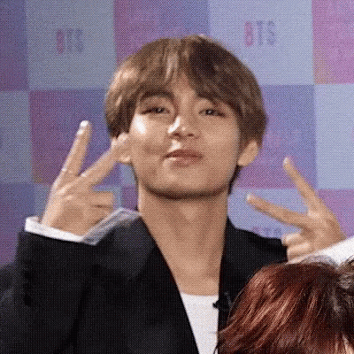 A Man In A Suit Giving A Peace Sign GIF