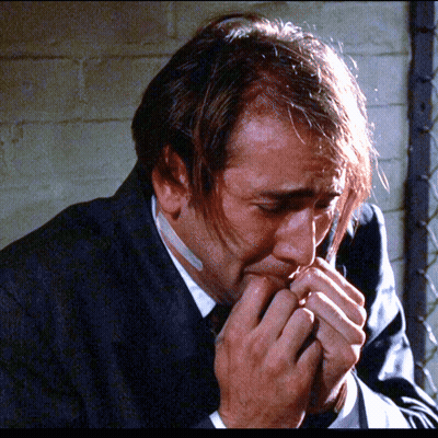 A Man In A Suit Has A Bandage On His Mouth GIF