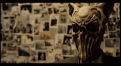 A Man In A Suit Has A Mask On His Face GIF