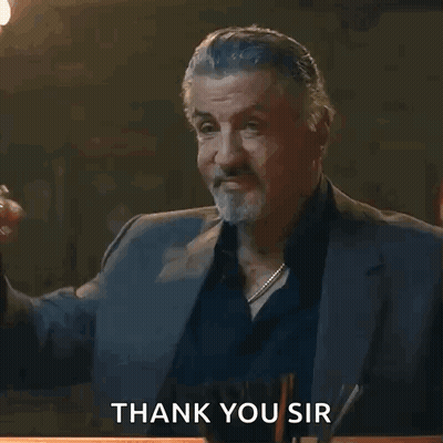 A Man In A Suit Holds A Glass Of Whiskey And Says Thank You Sir GIF