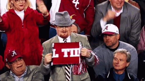 A Man In A Suit Holds A Sign That Says L Td GIF