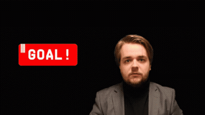A Man In A Suit Holds His Fist Up In Front Of A Sign That Says " Goal " GIF