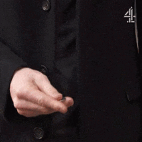 A Man In A Suit Is Adjusting His Jacket Sleeves . GIF