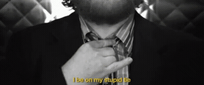 A Man In A Suit Is Adjusting His Tie With The Words I Be On My Stupid Tie Above Him GIF