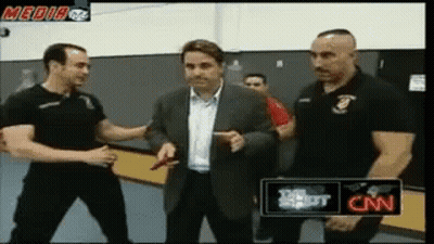 A Man In A Suit Is Being Interviewed By Two Men In Black Shirts With Cnn Written On The Bottom GIF