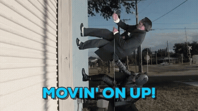 A Man In A Suit Is Being Lifted Up By A Batman GIF