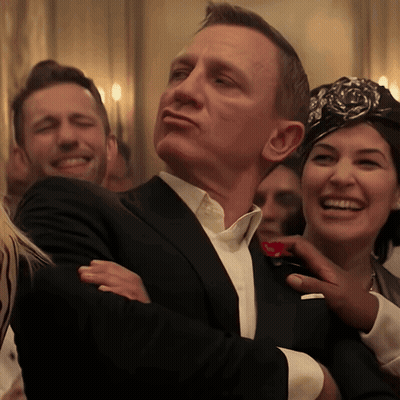 A Man In A Suit Is Being Touched By A Woman In A Headband GIF