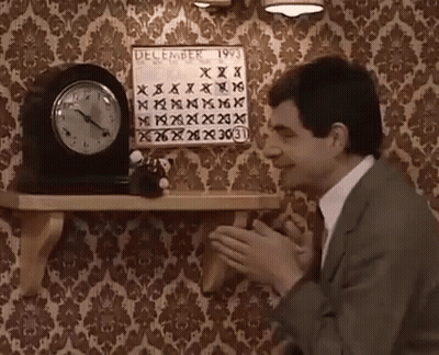 A Man In A Suit Is Clapping In Front Of A Calendar That Says December 1993 GIF