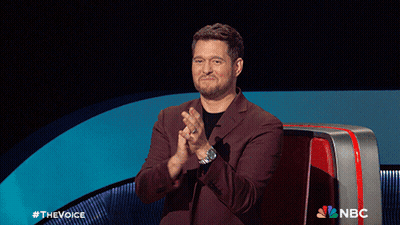 A Man In A Suit Is Clapping In Front Of A Nbc Sign GIF