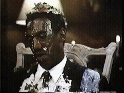 A Man In A Suit Is Covered In Cake GIF