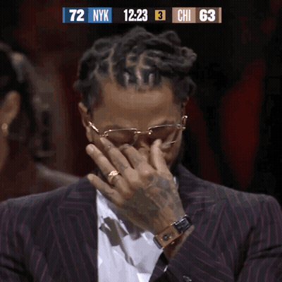 A Man In A Suit Is Covering His Face While Watching A Basketball Game GIF