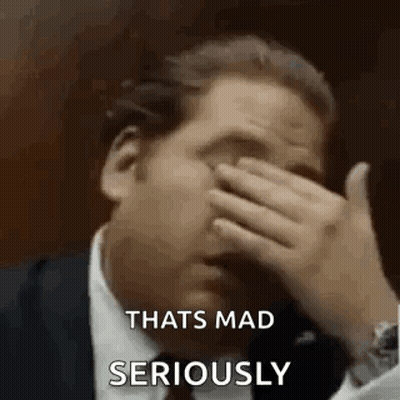 A Man In A Suit Is Covering His Face With His Hand And Saying `` That 'S Mad Seriously '' . GIF